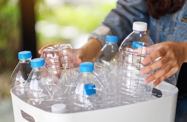 Eine Person sammelt zuhause recycelbare PET-Flaschen ein.